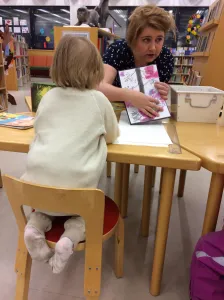 Lapsi askartelemassa omaa kirjaa työpajassa